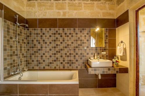 克伦蒂Ta' Majsi Holiday Home的带浴缸和盥洗盆的浴室