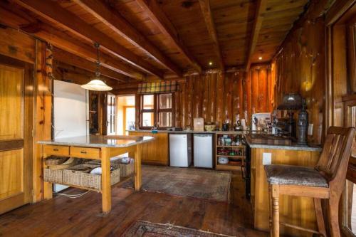 哈里史密斯Waterfall Retreat的厨房设有木墙、木地板和桌子