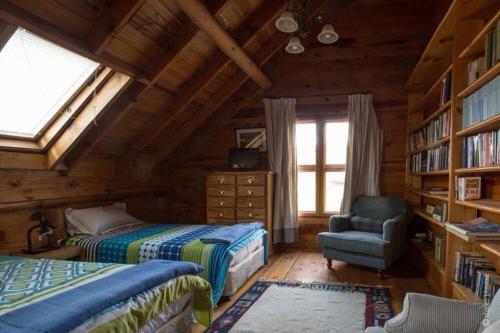 哈里史密斯Waterfall Retreat的小屋内一间卧室配有两张床和一把椅子