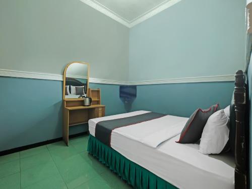 三宝垄Collection O 91914 Hotel Citra Dewi 2 Int's的一间卧室配有一张床和一张带镜子的桌子
