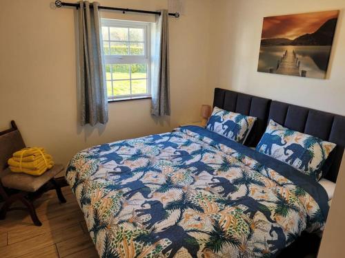 卡文Murray's Lodge: Self-Catering Accommodation.的一间卧室配有一张带五颜六色的被子的床和窗户