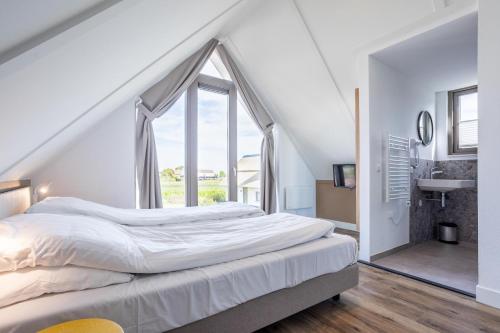 诺德韦克Duyndomein Noordwijk的一间卧室设有一张床和一个大窗户