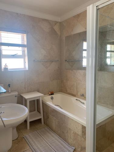 普利登堡湾River Club Vacation Home的带浴缸、卫生间和盥洗盆的浴室