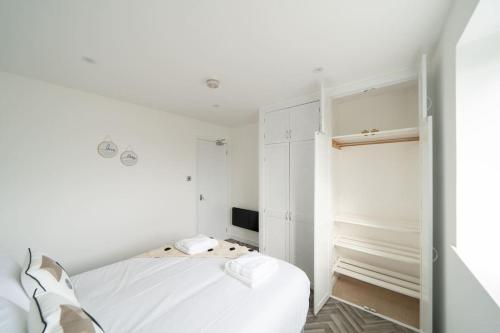 阿伯丁Links Loft -2 bed apartment minutes from Aberdeen beach的一间白色卧室,配有床和电视