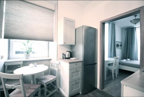 卢布林Zamojska Residence Apartments的一间带桌子和冰箱的小厨房