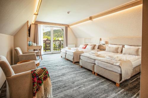 扎科帕内Villa Cannes Resort Zakopane - grota solna, sauna fińska的酒店客房,设有两张床和一张沙发