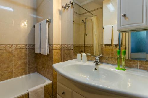 里斯本佛拉明哥酒店的一间带水槽、浴缸和镜子的浴室