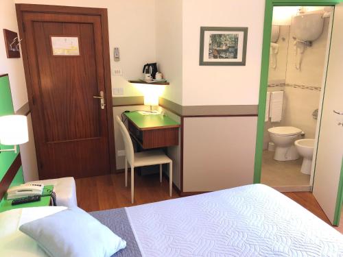 佩鲁贾希尼雅酒店的一间卧室配有一张床、一张书桌和一个卫生间