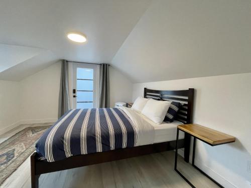 尤克卢利特Salt Loft - Oceanfront, Hot Tub And Firepit!的一间卧室配有一张带桌子和窗户的床