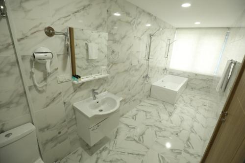 伊斯坦布尔El Emin İstanbul Hotel的白色的浴室设有水槽和淋浴。