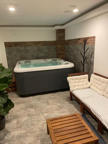 TatobityApartmány U Lípy的客厅设有按摩浴缸和两张沙发