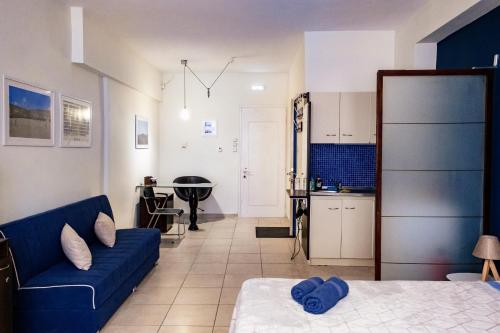 科莫蒂尼PARASIOU STUDIOS 107 διαμερίσματα στο κέντρο της πόλης的一间带蓝色沙发的客厅和一间厨房