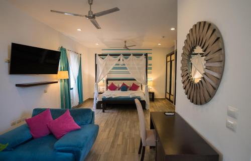 普拉亚卡门波萨达马里波萨第五大道精品酒店的客厅配有蓝色的沙发和床。