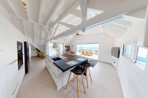 圣马丁岛Walee Beach Penthouse by the sea, 2 bedrooms, pool的厨房配有白色橱柜和黑色台面