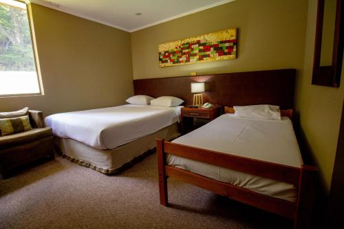 奇廉内瓦达斯奇廉内瓦达斯酒店的酒店客房,配有两张床和椅子
