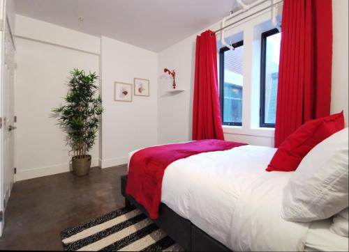 哈利法克斯Cameo Hotel and Suites的一间卧室配有一张带红色窗帘的大床