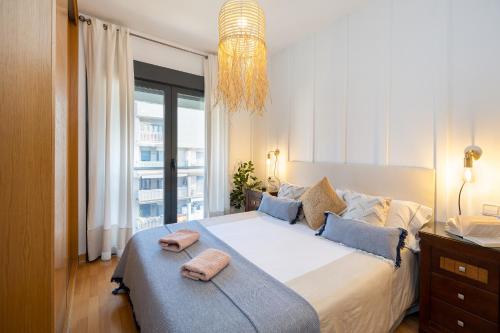 格拉纳达Apartamentos Arcoíris的一间卧室配有一张大床和两条毛巾