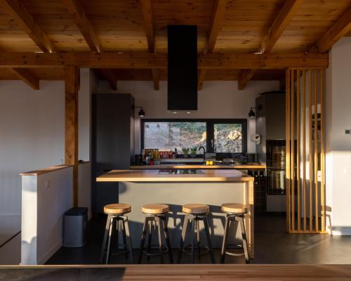 莱斯诺夫Mountain Lodge的厨房设有木制天花板和酒吧凳子。