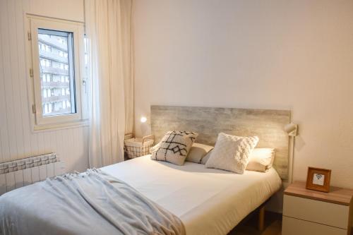 帕斯底拉卡萨ESTUDIO AVET - Perfecta ubicación的一间卧室配有一张带白色床单的床和一扇窗户。