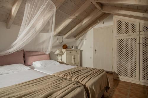 Makhairádhon卡拉马拉斯皮瑞特别墅的一间卧室配有一张大床和窗帘
