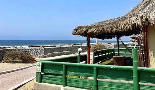 维加伊托维查伊托简易别墅及小茅屋的海滩旁的绿色长凳,带小屋