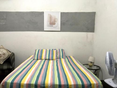 纳塔尔Pousada Cisne Branco的一间卧室配有一张带彩色条纹床单的床