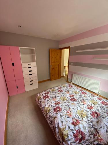卡舍尔Town villa with charming garden, bbq area & Sleeps 6的一间卧室配有一张床,拥有粉红色和紫色的墙壁