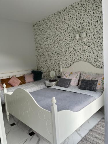 ŚciegnyDobra1的卧室内的两张床,配有花卉壁纸