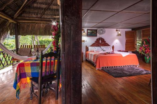 Tlatizapán恰帕斯塞尔瓦拉坎多纳拉斯瓜卡马亚斯山林小屋的一间卧室配有一张床和吊床