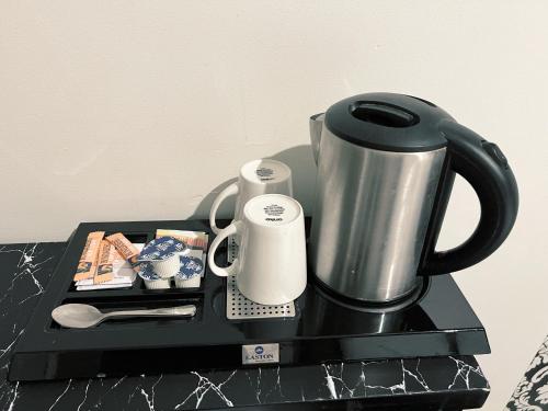 悉尼悉尼精品酒店的黑色盘子,带咖啡壶和杯子