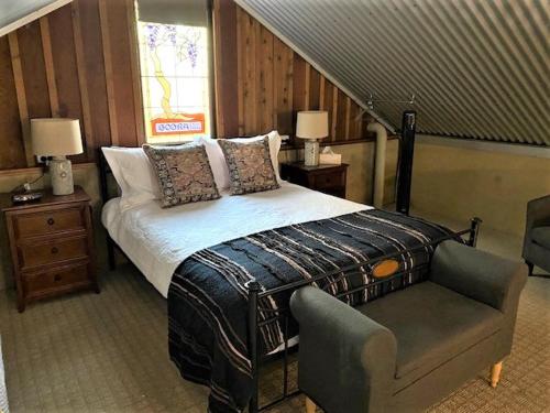 达博内陆酒窖乡村民宿的一间卧室配有一张床、一把椅子和楼梯