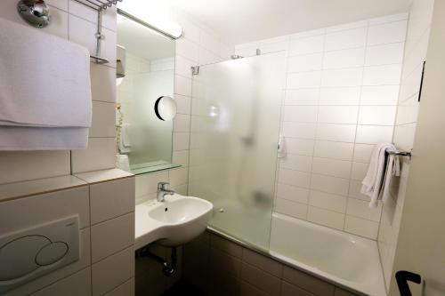 埃森Atelier Hotel Essen-City的白色的浴室设有水槽和淋浴。