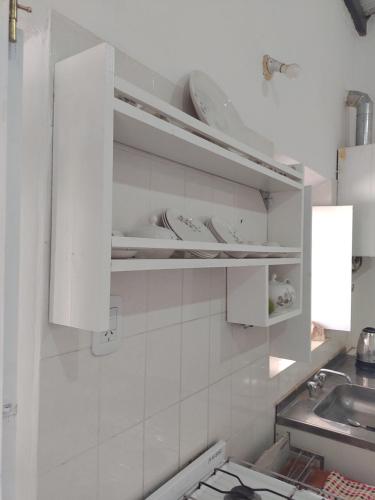 蒂尔卡拉Casa de Barro Tilcara的厨房配有白色橱柜和水槽