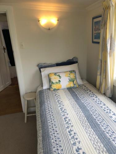 玛普瓦Ferntree Cottage的一间卧室配有一张带蓝色和白色棉被的床