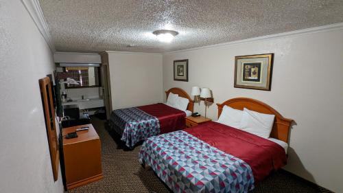 EufaulaEufaula Inn的酒店客房设有两张床和电视。