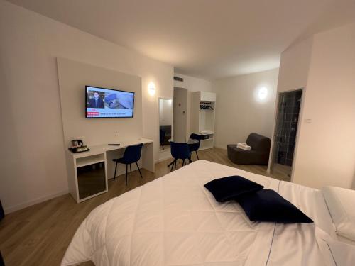 奇维塔韦基亚Hotel Smart Cruise的一间卧室配有一张床和一张书桌,墙上配有电视。