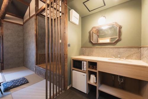 高松Traditional Apartment Takamatsu Guesthouse的一间带水槽和镜子的浴室