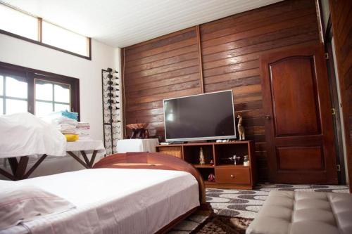莱蒂西亚Casa Finca Villa Laura的一间卧室设有两张床,墙上配有电视。