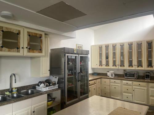 圣何塞Casa Escalante Hostel的厨房配有不锈钢冰箱和木制橱柜