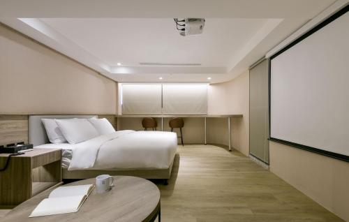 台中市春树商旅的酒店客房,配有床和投影屏幕