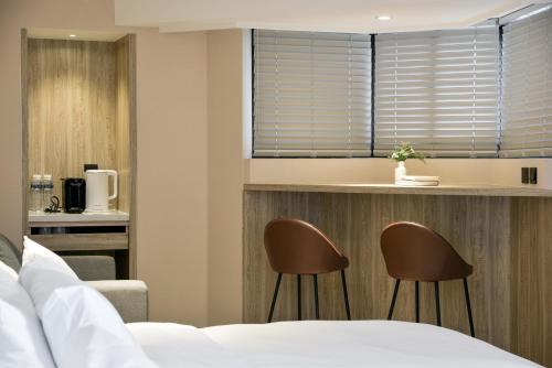 台中市春树商旅的酒店客房带两把椅子和一张床