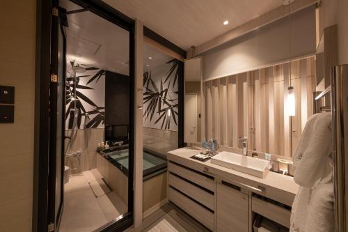 东京HOTELみなと-MINATO-的一间带水槽、淋浴和镜子的浴室