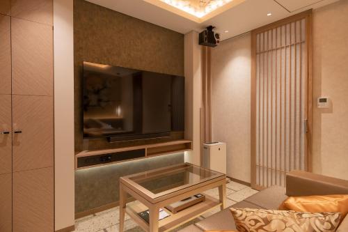 东京HOTELみなと-MINATO-的客厅配有电视、沙发和桌子