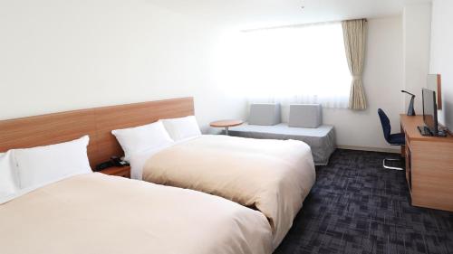 广岛广岛米尔帕曲酒店的酒店客房设有两张床和窗户。
