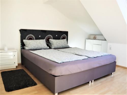 莱比锡Kuschelige Dachgeschosswohnung am Clarapark的一间卧室配有一张带黑色床头板的床