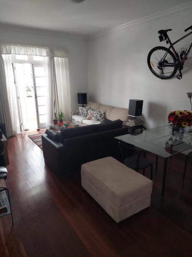里约热内卢Quartos em Laranjeiras的客厅配有沙发和桌子,墙上挂有自行车