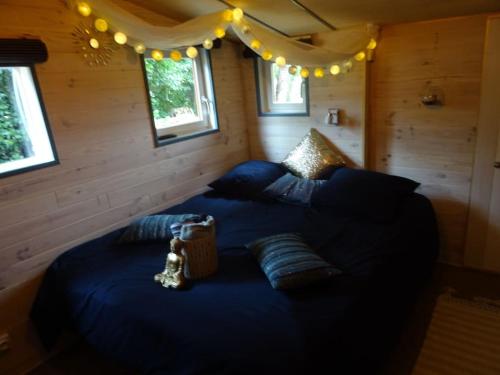 利布尔讷Chalet avec spa à Libourne proche St-Emilion的一间卧室配有蓝色的床、枕头和灯