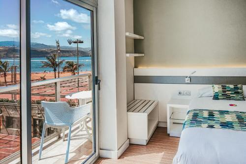 大加那利岛拉斯帕尔马斯Hotel Aloe Canteras的一间卧室设有一张床和一个美景阳台