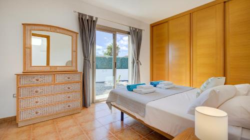 科斯塔德安提瓜Villa Melissa的一间卧室配有一张床、镜子和窗户