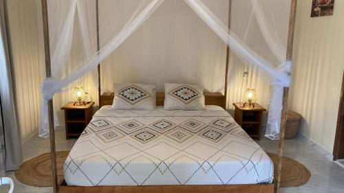 NdanganeVilla Kounzo的一间卧室配有白色床和2个床头柜